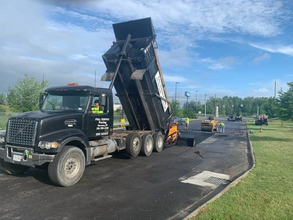 A dump truck is sitting on the side of a road.