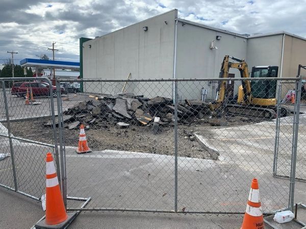 A construction site with a chain link fence and orange cones