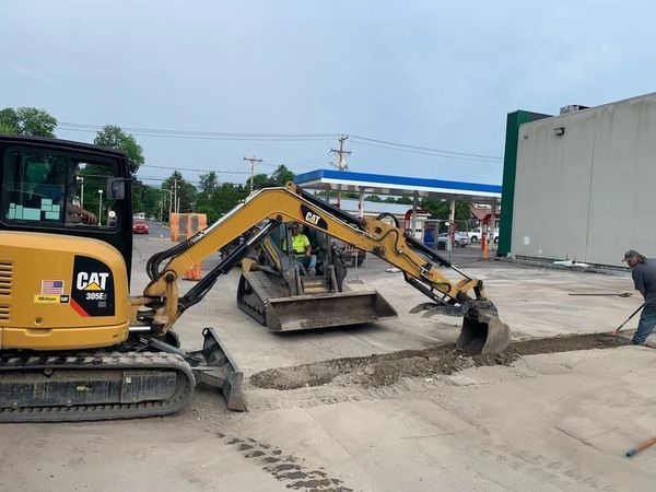 A cat excavator is being used to dig a hole in the ground.