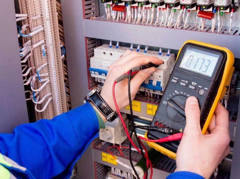 Electrician testing a commercial consumer unit for a Derby business