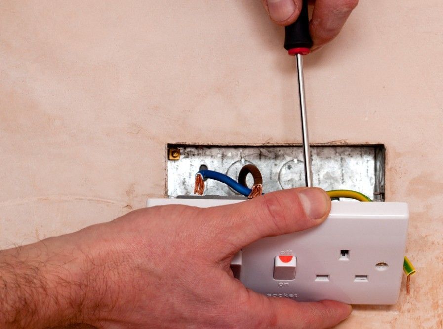 Derbyshire Electrical Specialist installing a new socket in a freshly plastered wall