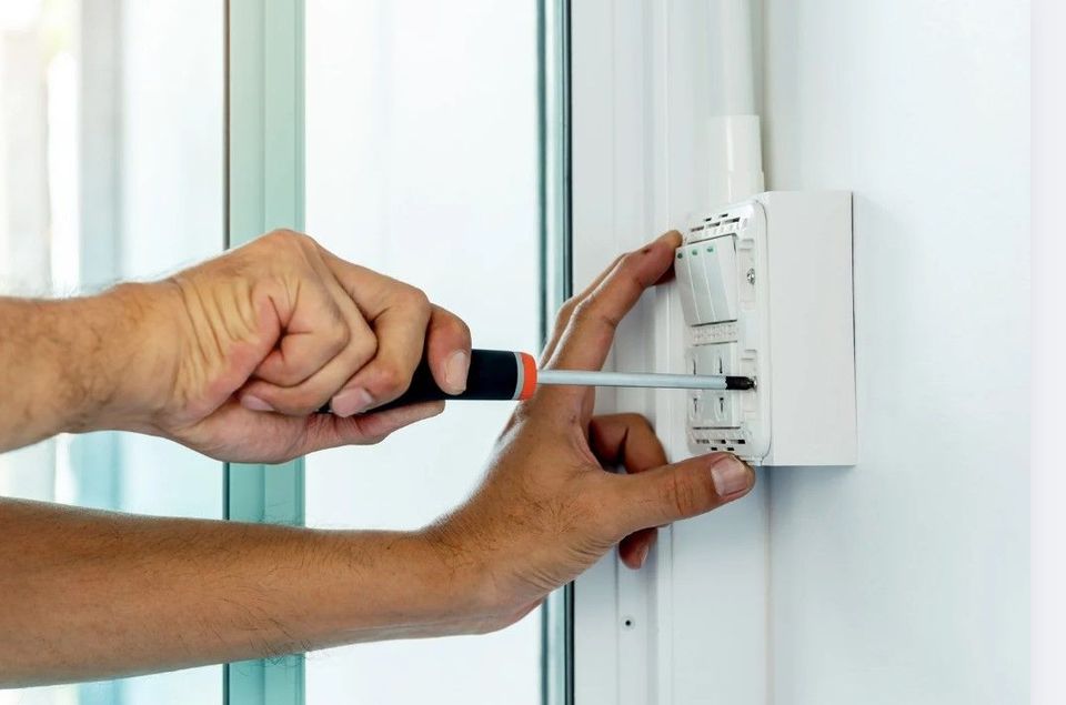 Electrician fitting electrical accessories in a Derby office