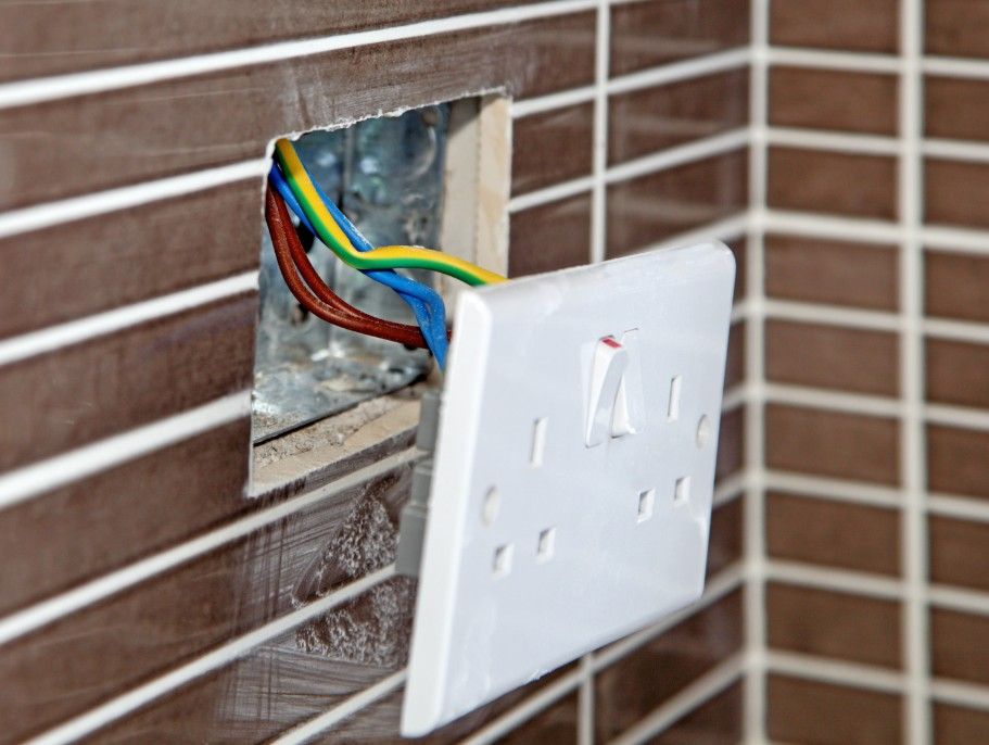 Derbyshire Electrical Specialist installing a new socket in a tiled wall