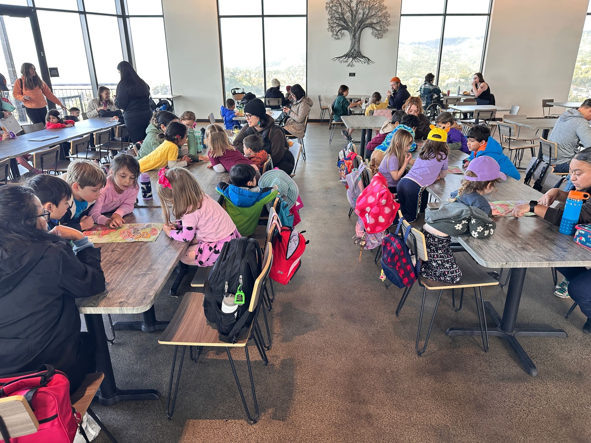 A group of Montessori child are sitting at tables in a restaurant at the Oakland Zoo.