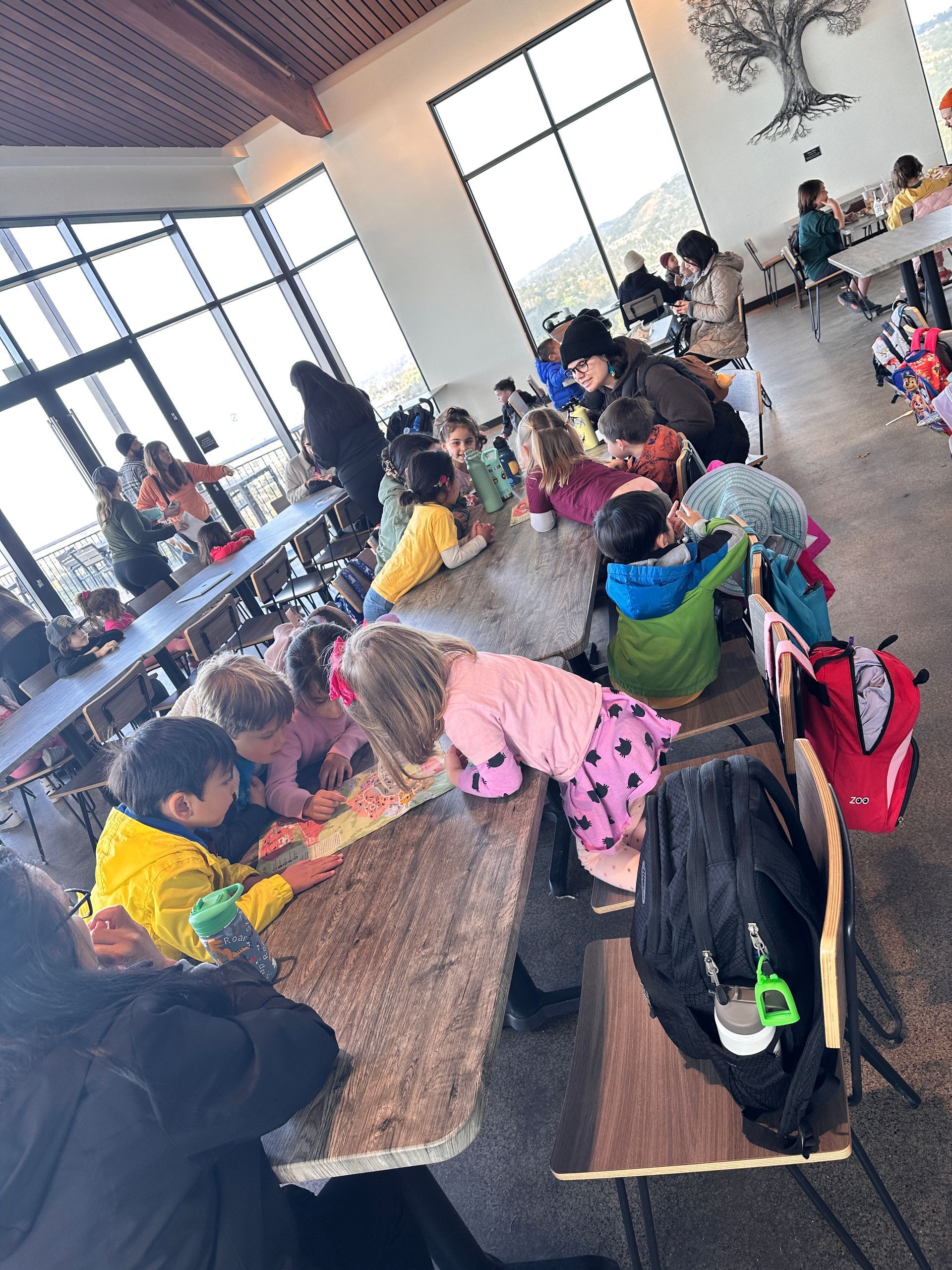 A group of Montessori child are sitting at tables in a restaurant at the Oakland Zoo.