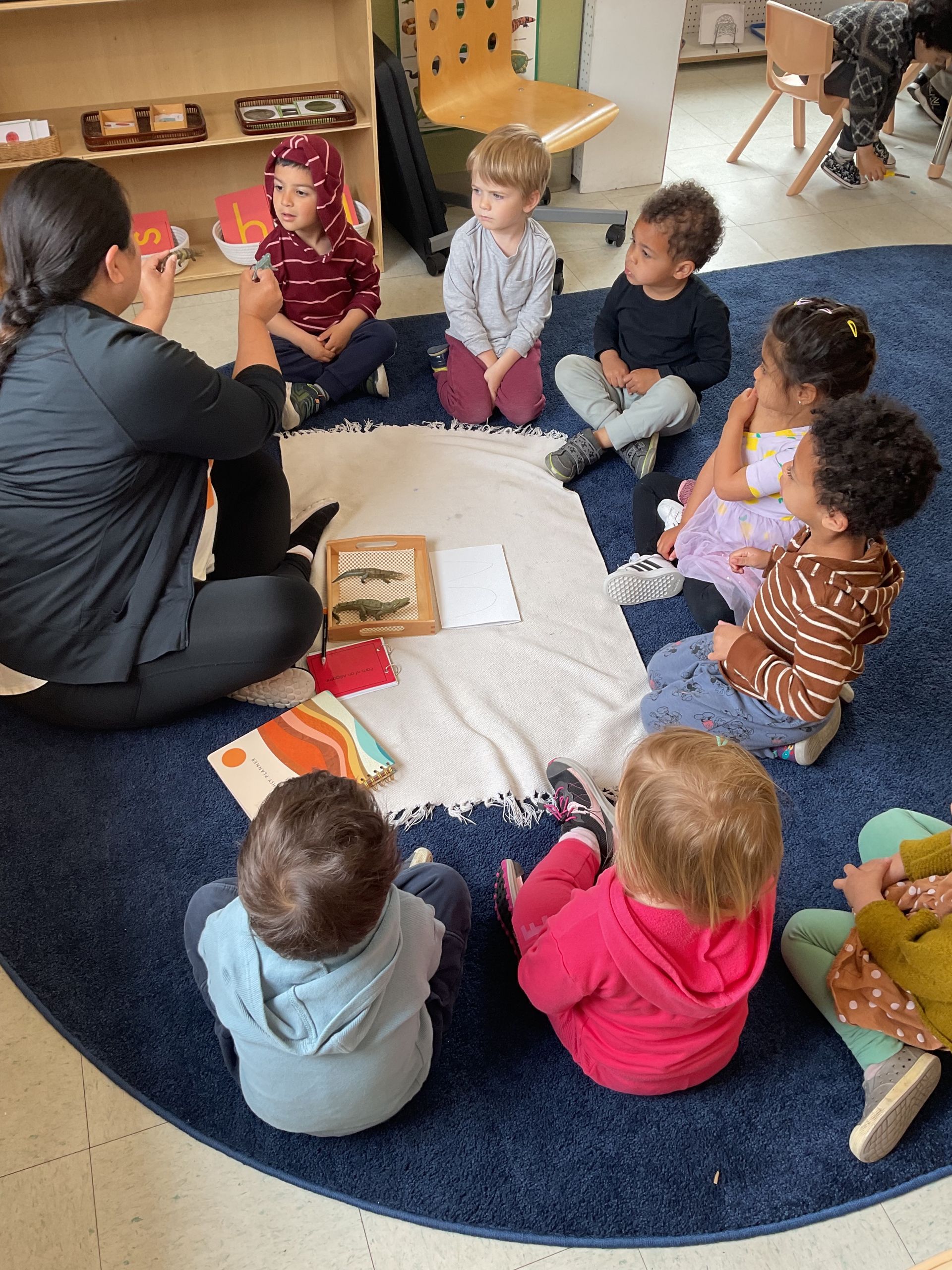 montessori children with guide having some lessons about dinosaurs