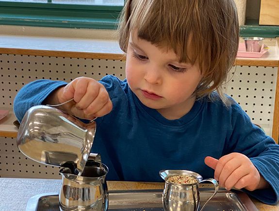 Montessori toddler working on practical life skills 
