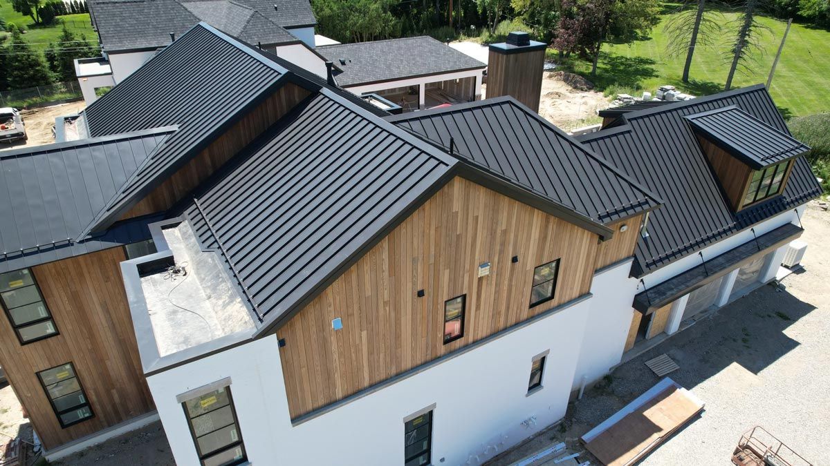 Aerial shot of a home with a standing seam metal roof, highlighting precision and quality installation. Roofing contractor serving Gaylord, MI.