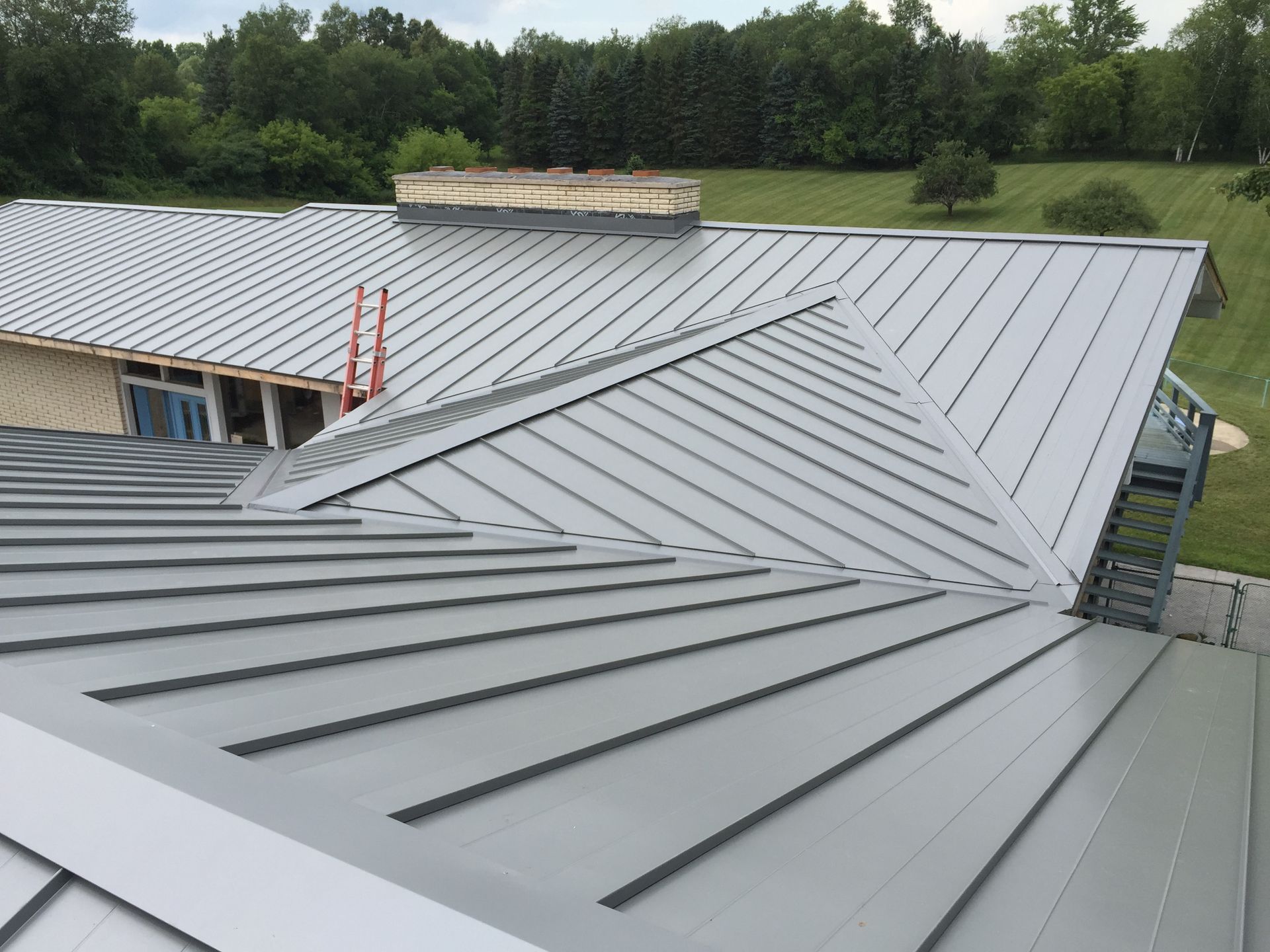 Home with a striking metal roof, blending precision installation with durable materials. Serving Gaylord, MI for all your roofing needs.