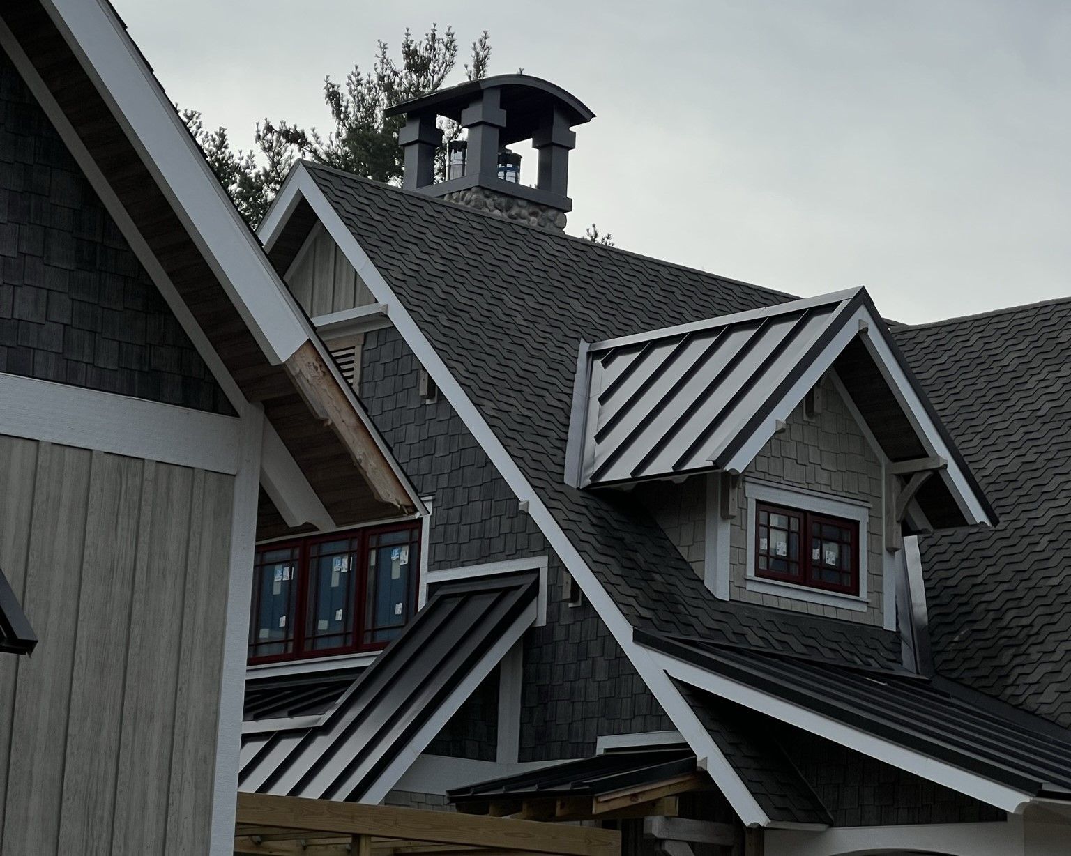 Beautiful combination of metal and shingle roofing on a residential home. Modern design and expert craftsmanship in Arenac County.
