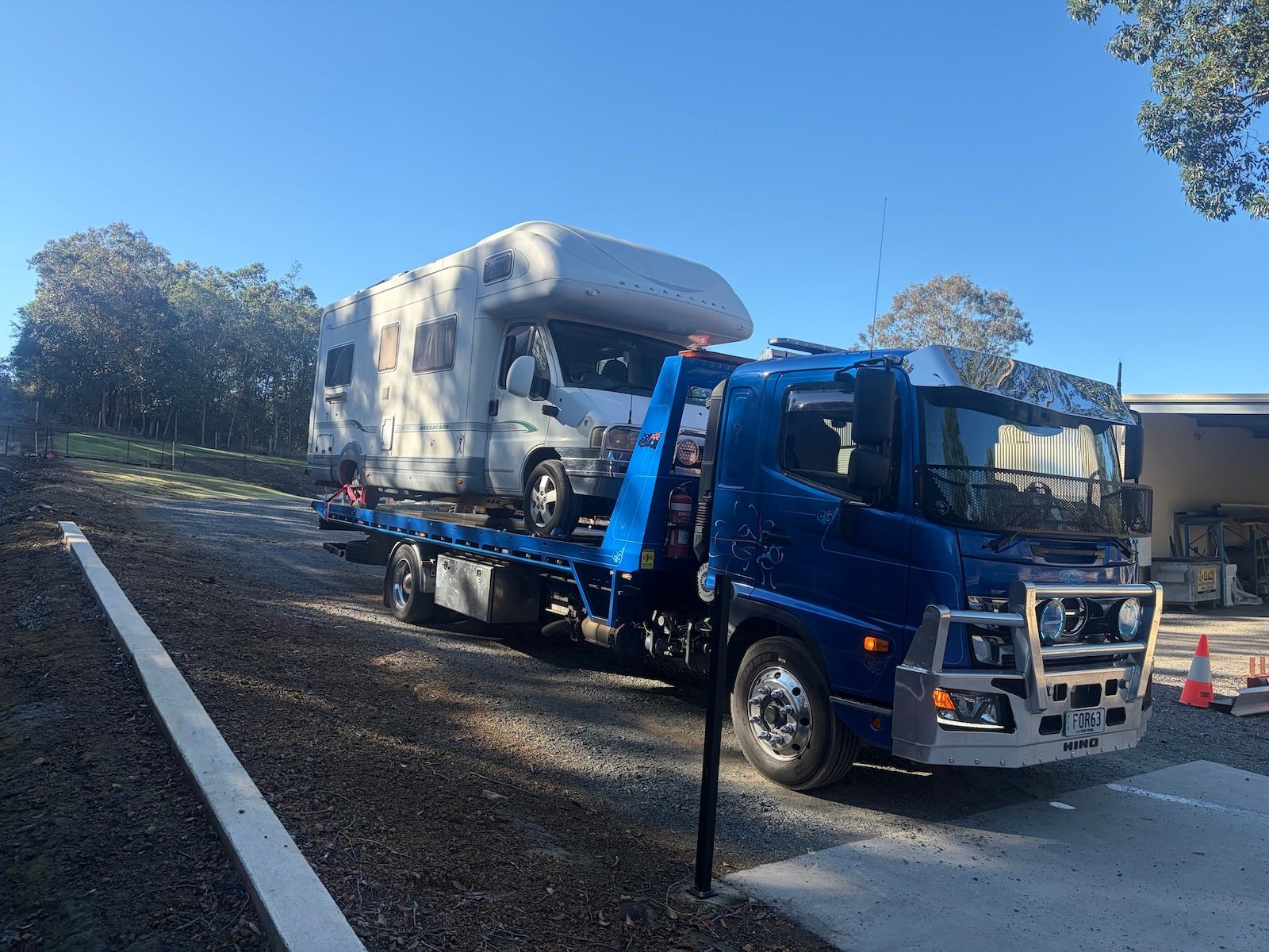 Tow Truck Carrying a Blue Sedan on a Sunny Suburban Street — A B & Forge Towing In Caboolture, QLD