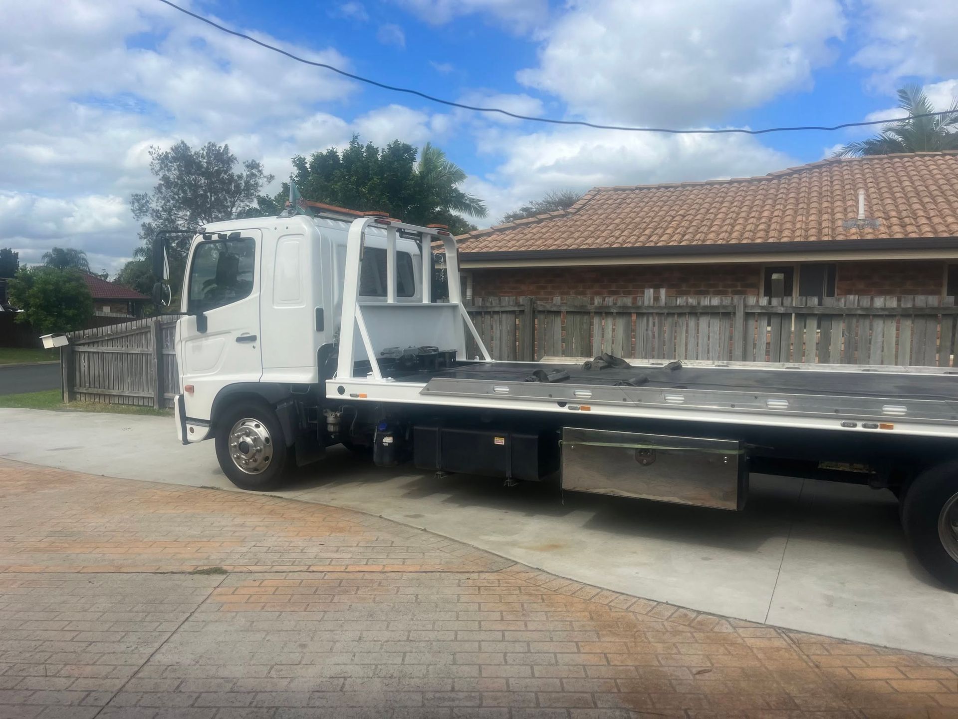 White Flatbed Truck Parked Beside a Tiled-roof Building — A B & Forge Towing In Bribie Island, QLD