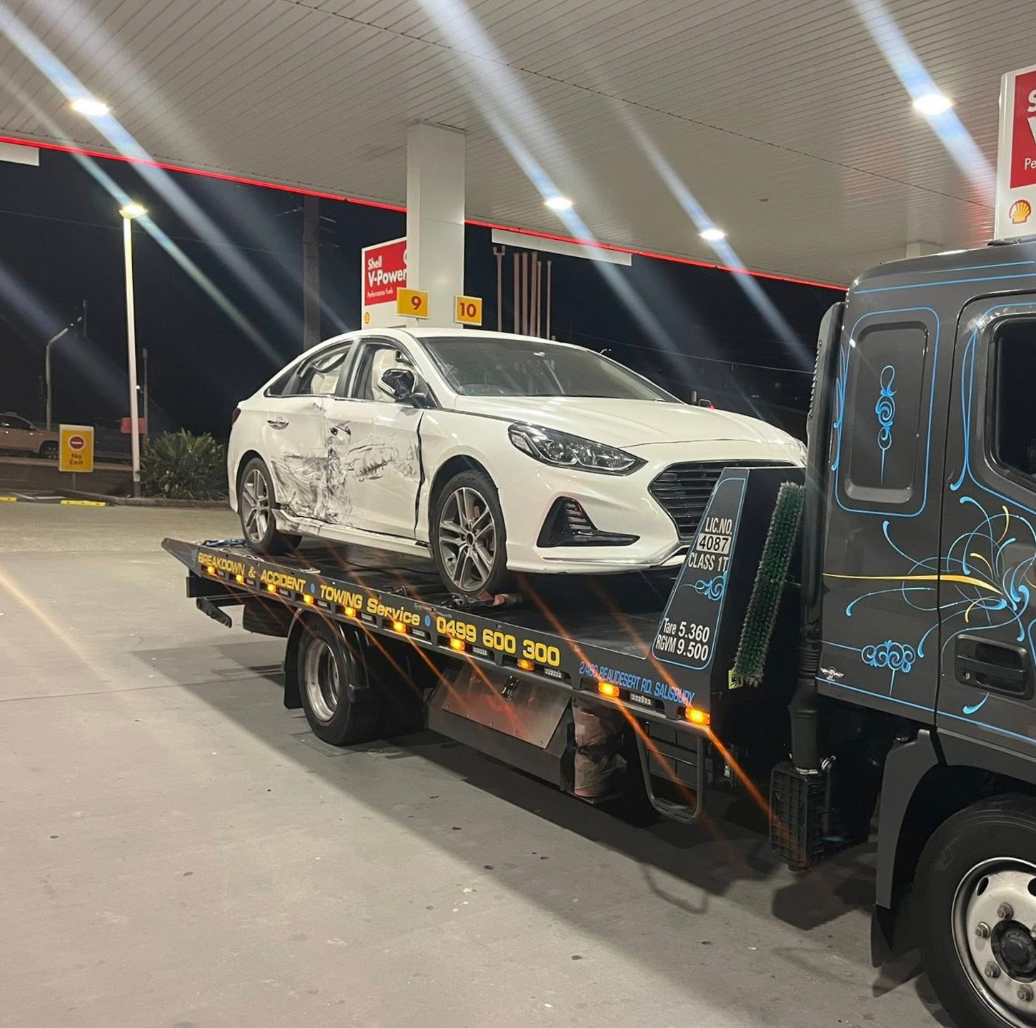 White Sedan Loaded on a Tow Truck at a Gas Station at Night — A B & Forge Towing In Caboolture, QLD