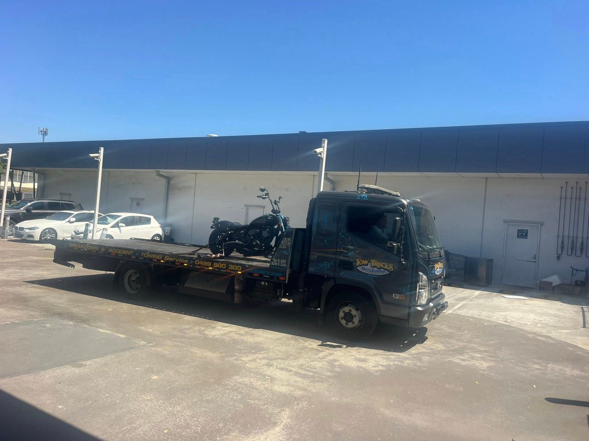 Black Flatbed Tow Truck Parked Outside a Warehouse — A B & Forge Towing In Caboolture, QLD