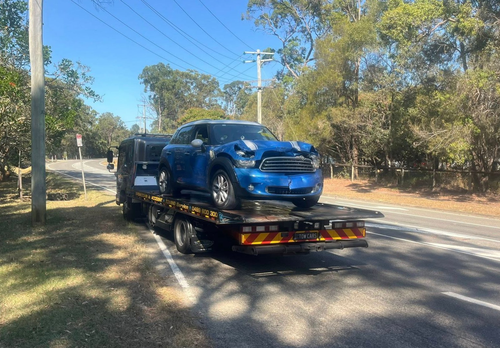 Blue SUV on a Flatbed Tow Truck on a Tree-lined Roadside — A B & Forge Towing In Morayfield, QLD