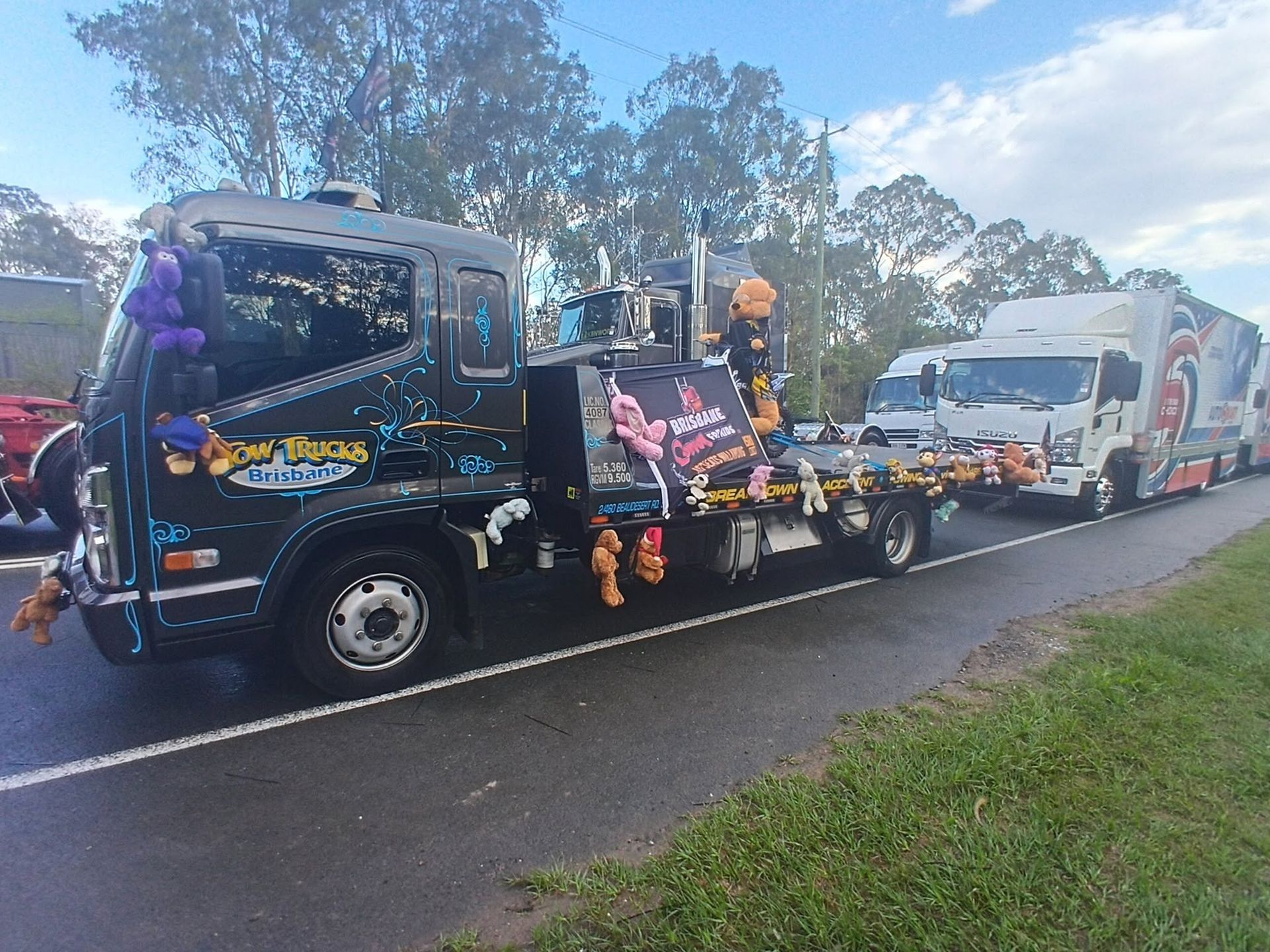 Decorated Tow Truck Hauling a White Van on a Wet Roadside — A B & Forge Towing In Morayfield, QLD