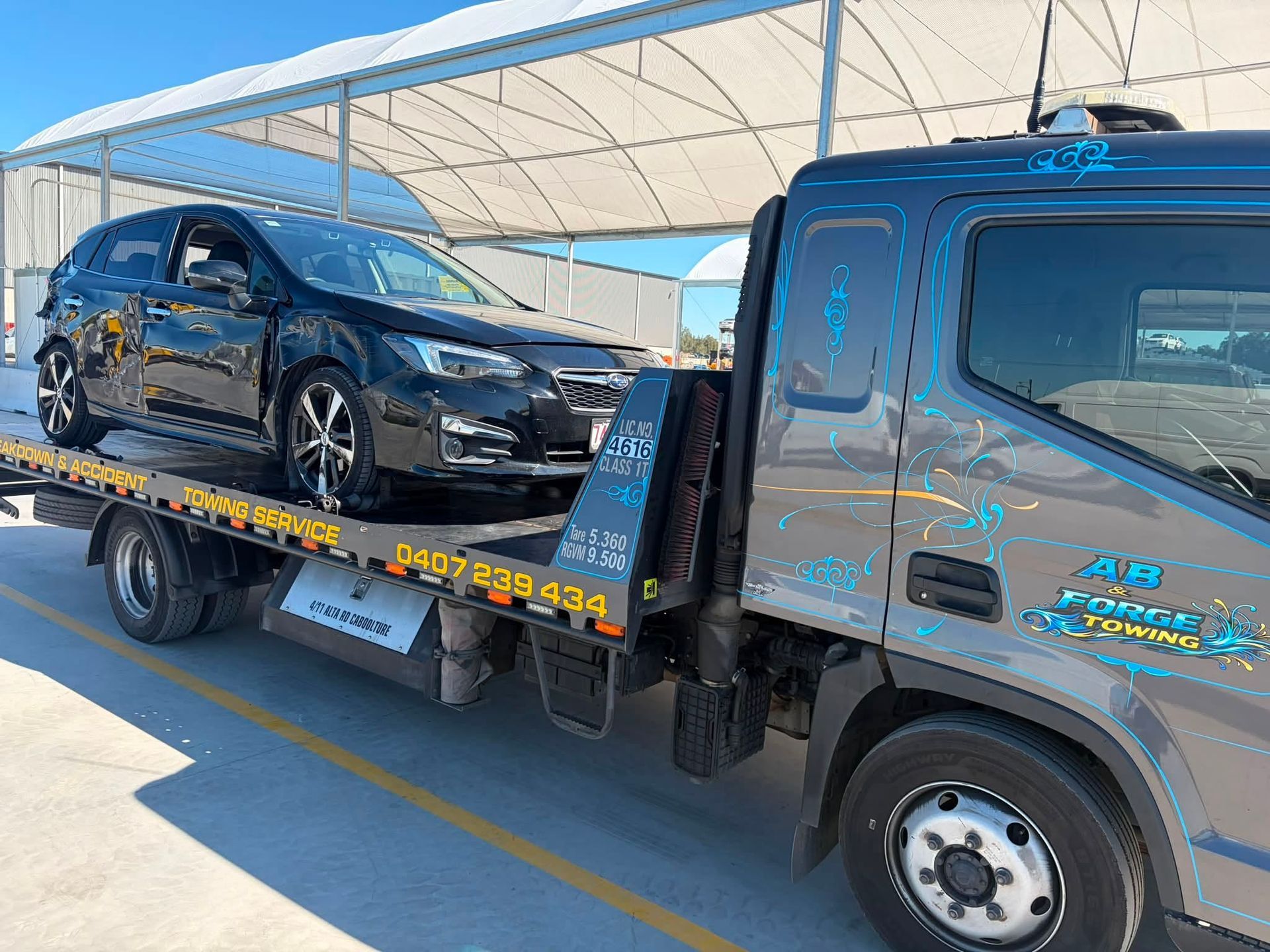 Black SUV Loaded on a Tow Truck Under a Covered Lot — A B & Forge Towing In Burpengary, QLD