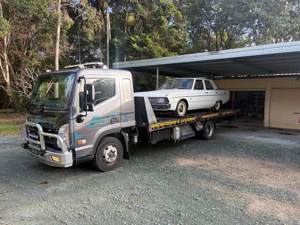 Tow Truck Carrying a Black Sedan on a Flatbed — A B & Forge Towing In Caboolture, QLD