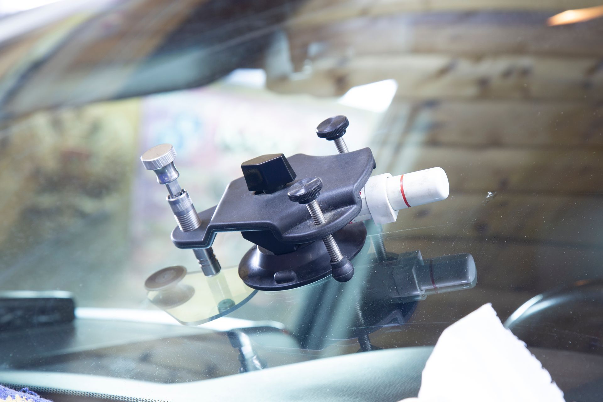 Car windshield phone mount with adjustable clamp and suction cup, holding a device on the dashboard
