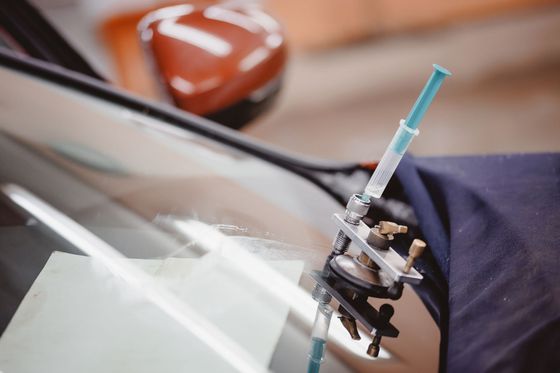Person installing or removing a car window tint on a white vehicle