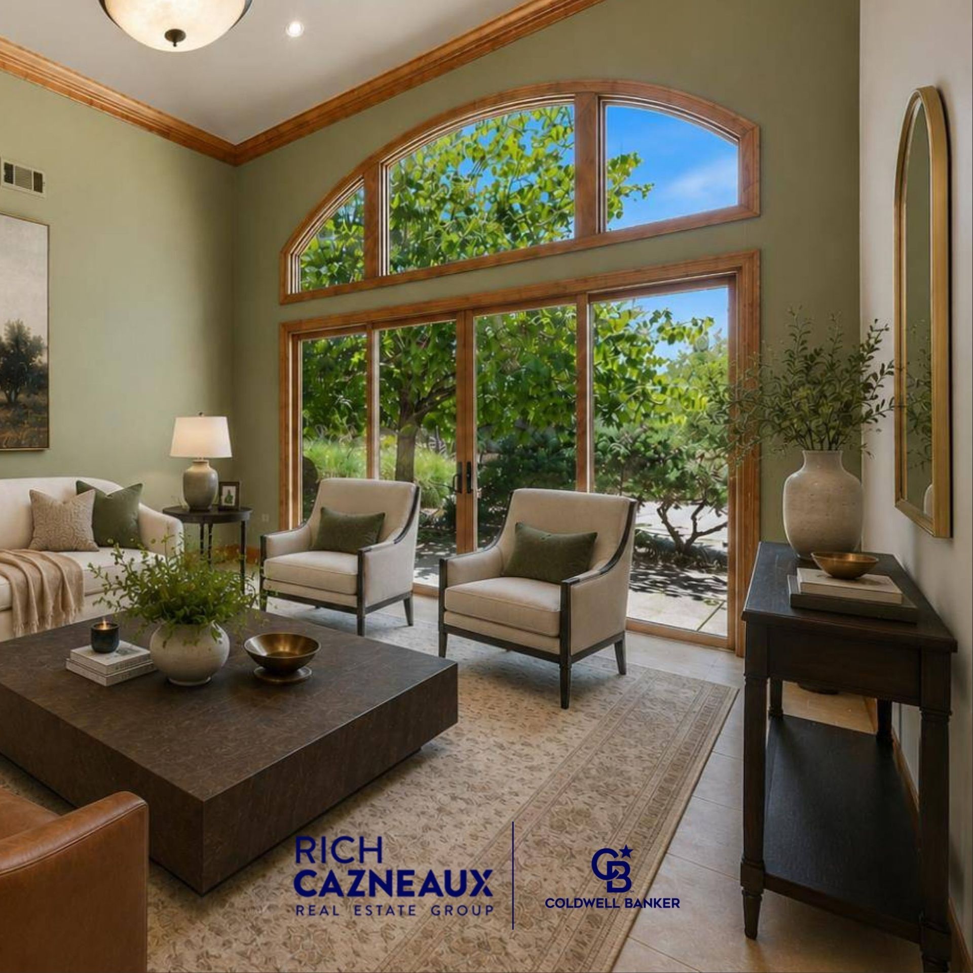 Bright living room featuring high ceilings, neutral seating, a dark wood coffee table, and large arched windows.