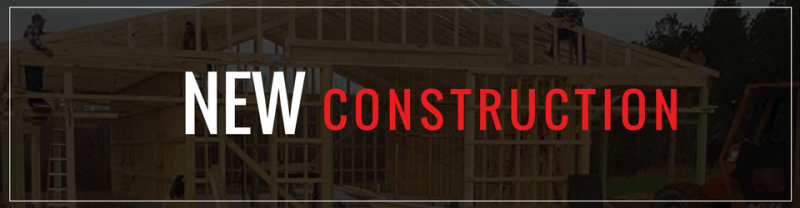 A wood-framed house under construction with the text 