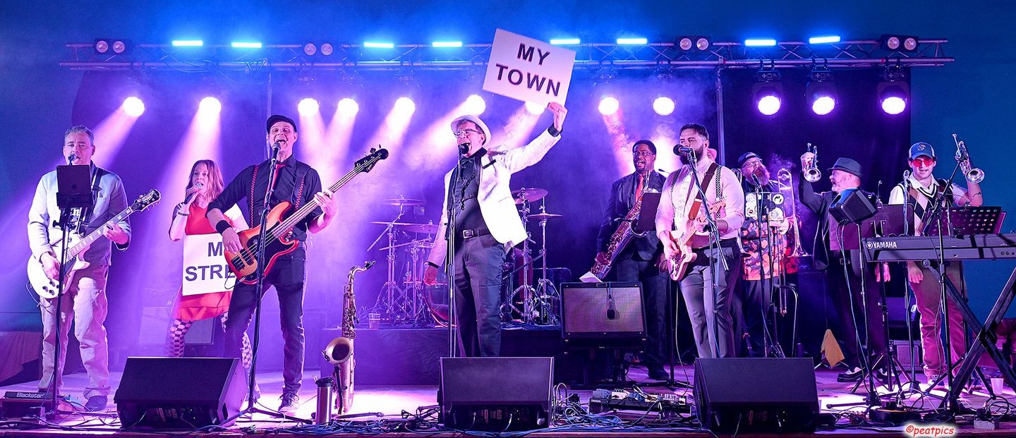 A group of men are playing guitars on a stage