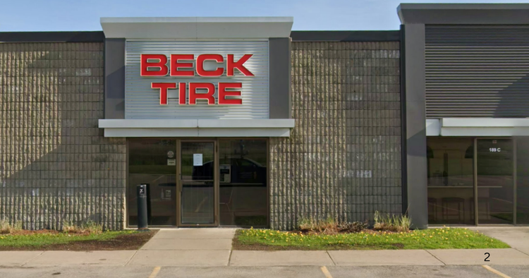 Beck Tire storefront with glass doors, red sign, and neighboring businesses on a sunny day
