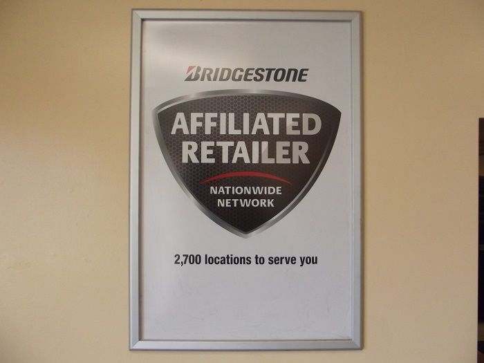 Bridgestone Affiliate Retailer poster in a silver frame on a beige wall