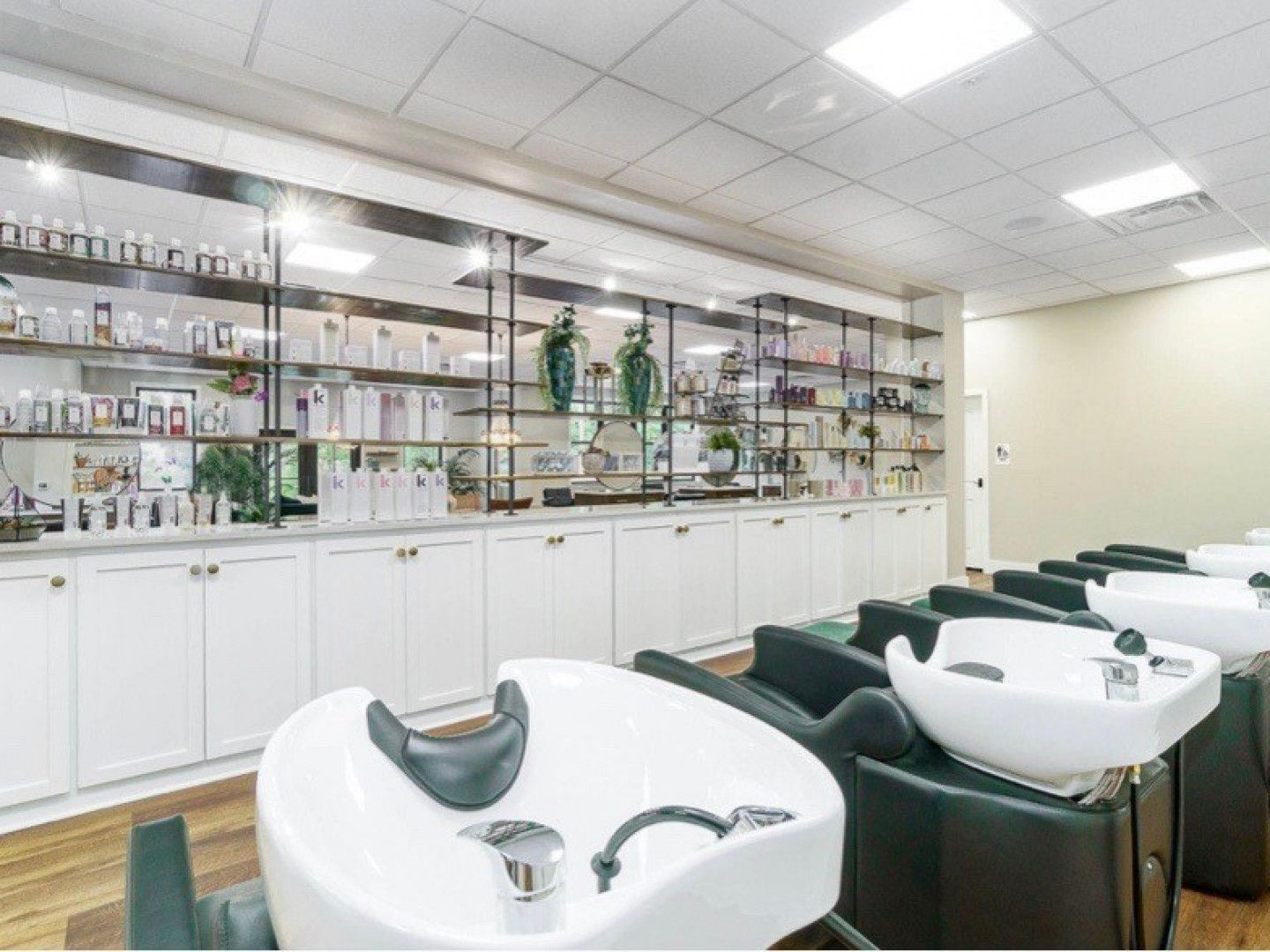A hair salon with a lot of sinks and chairs.