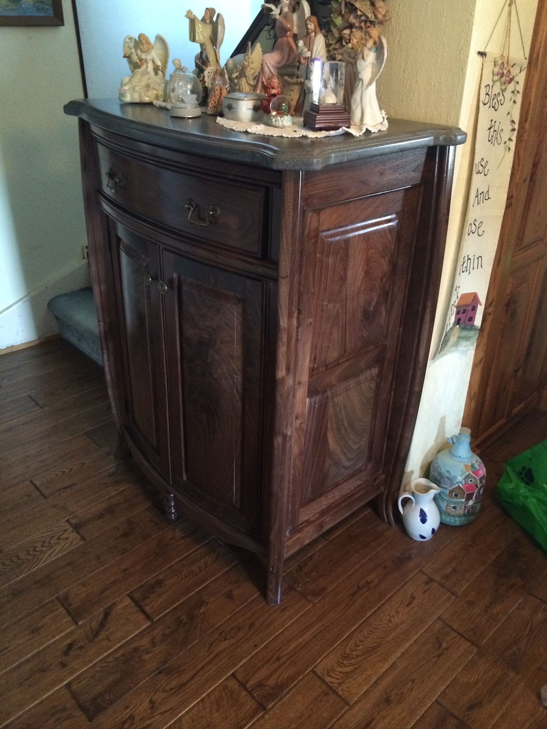 A wooden cabinet is sitting on a wooden floor in a room.