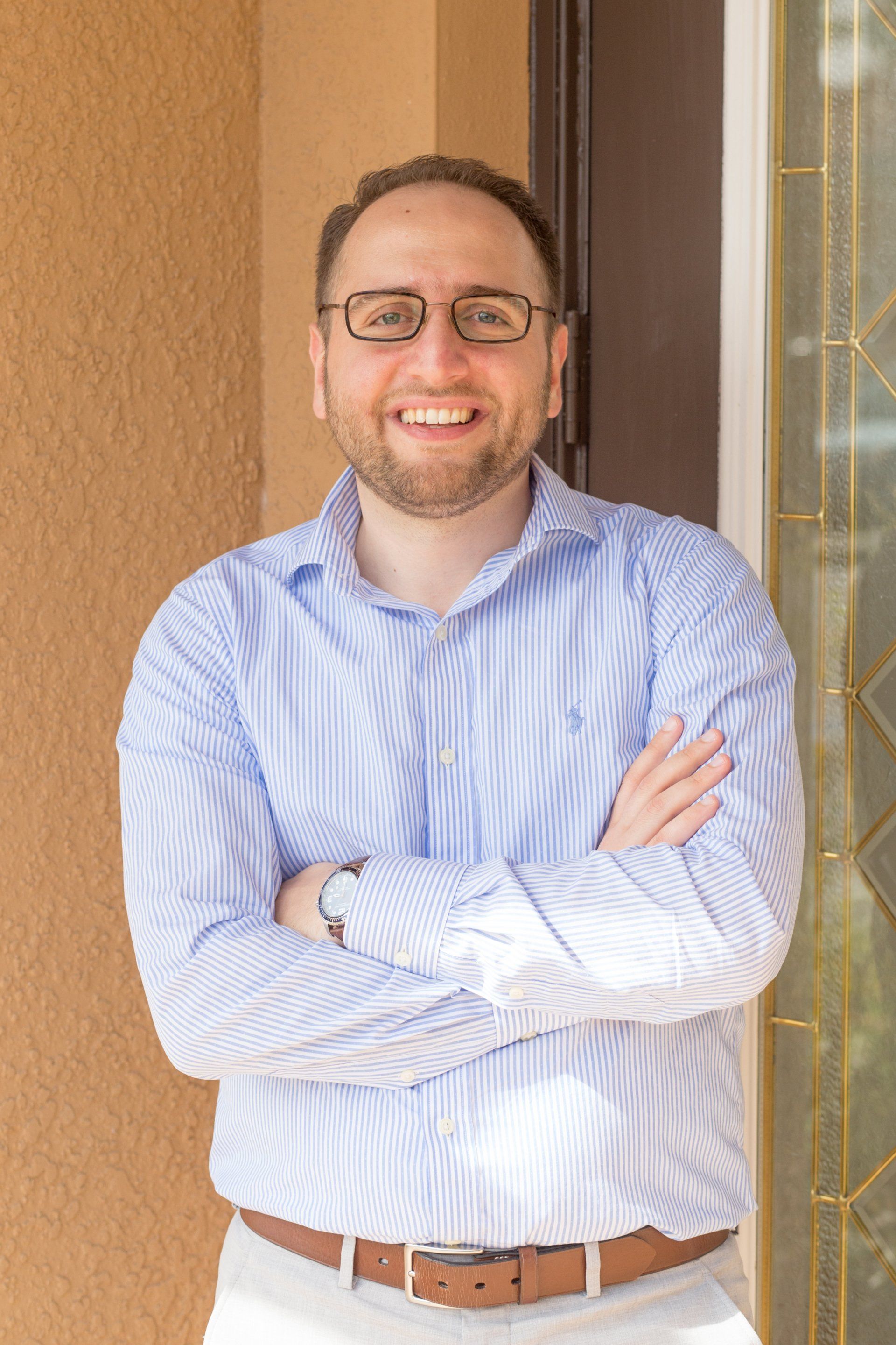 Florida TMS Clinic sign beside a smiling man in a blue suit standing at a reception counter.
