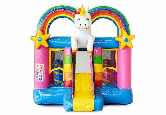 Kleurrijk springkussen in de vorm van een eenhoorn met glijbaan, regenboogboog en sterrenversieringen.