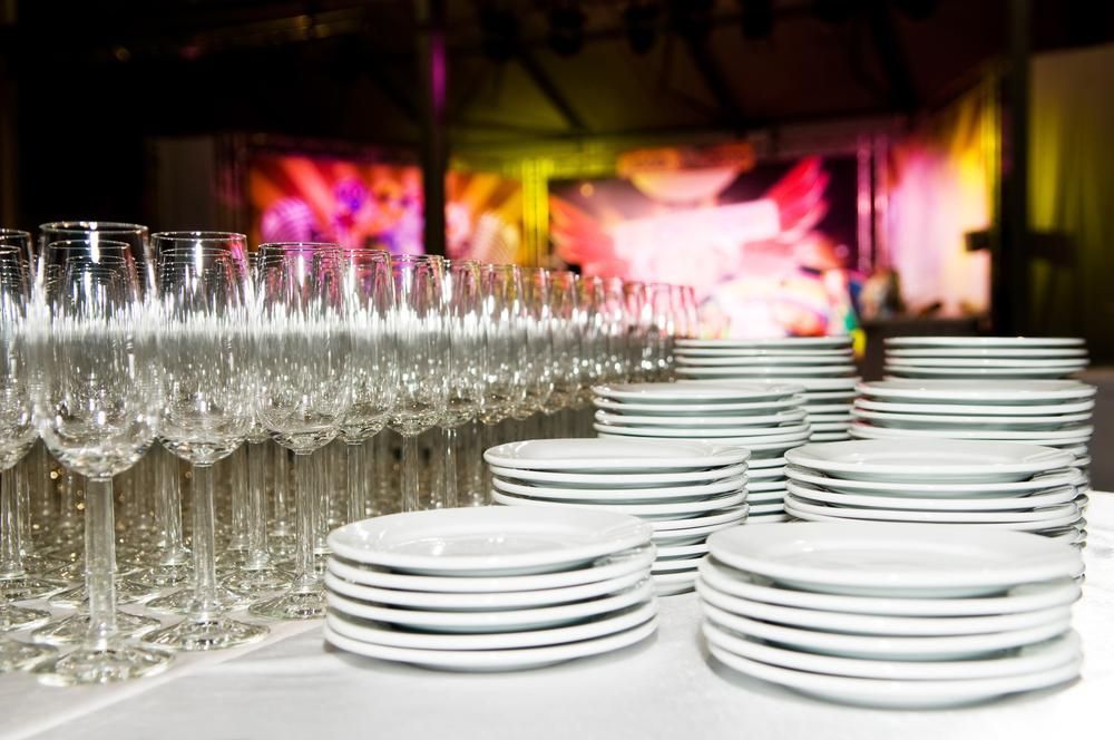 A Table with Plates and Wine Glasses on It — Mackay Cleaning & Packaging Supplies in Mackay, QLD