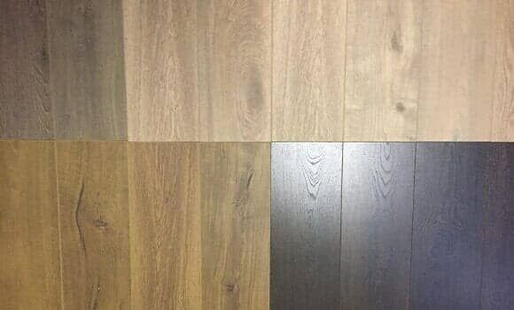 A grid displaying four distinct wood plank flooring samples, featuring light, medium, and dark brown color variations.