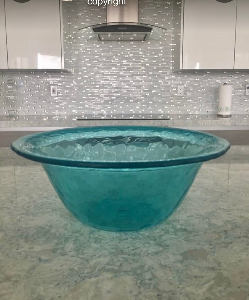 A large blue bowl is sitting on a counter in a kitchen