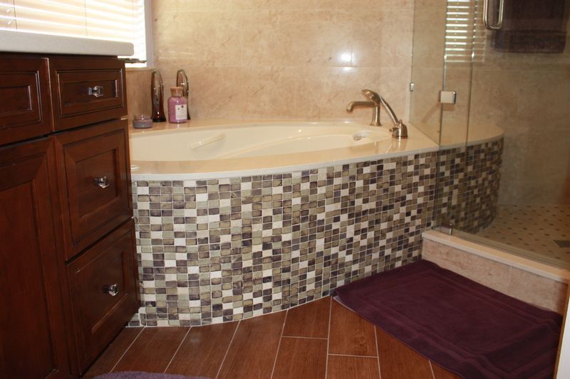 A bathroom with a jacuzzi tub and a walk in shower