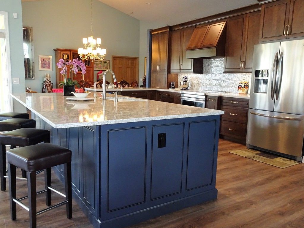 A kitchen with a large blue island and stools
