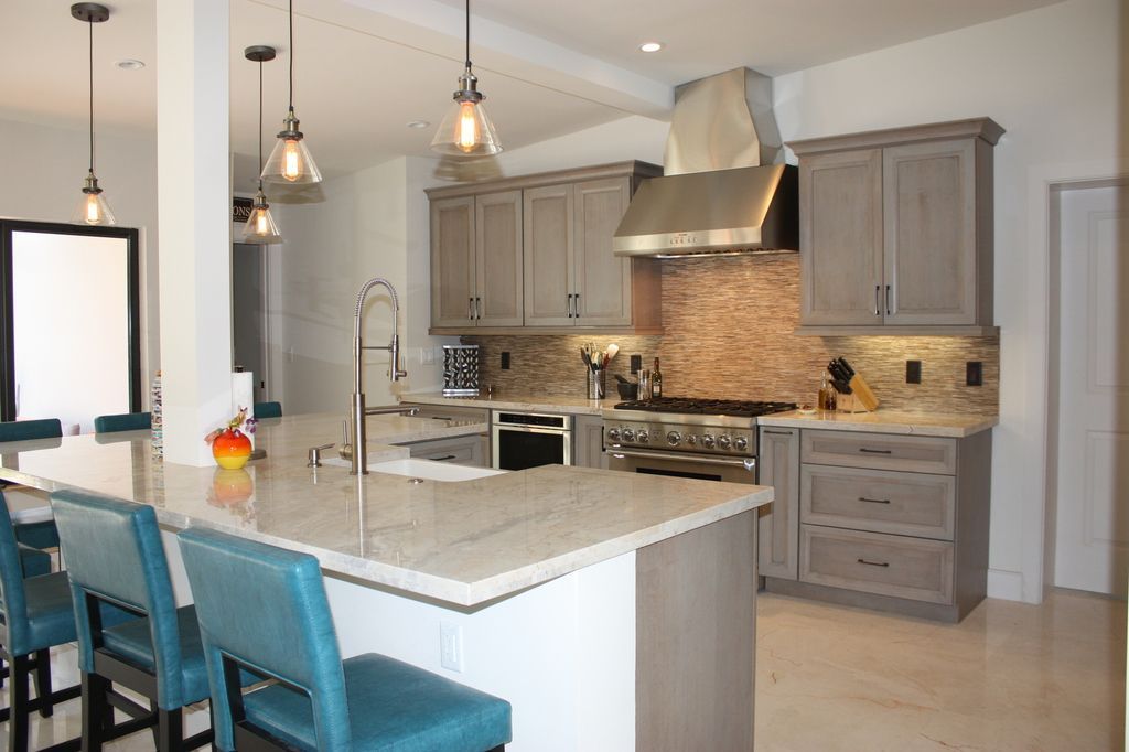 A kitchen with gray cabinets and white counter tops