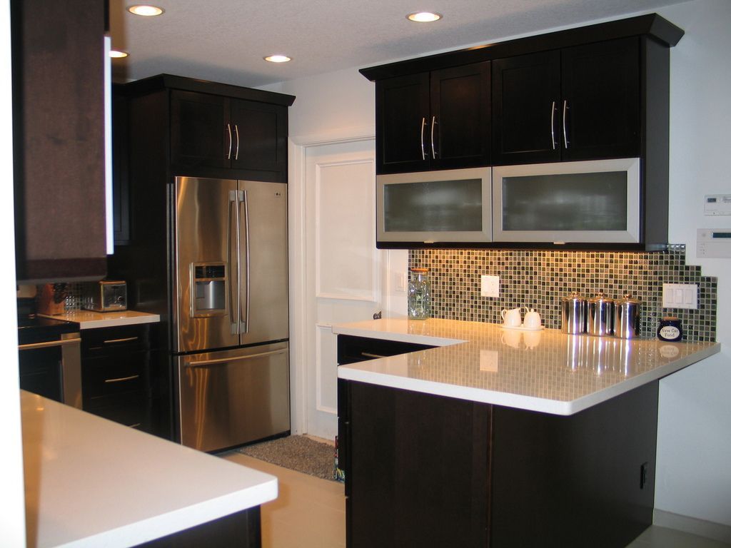 A kitchen with stainless steel appliances and black cabinets
