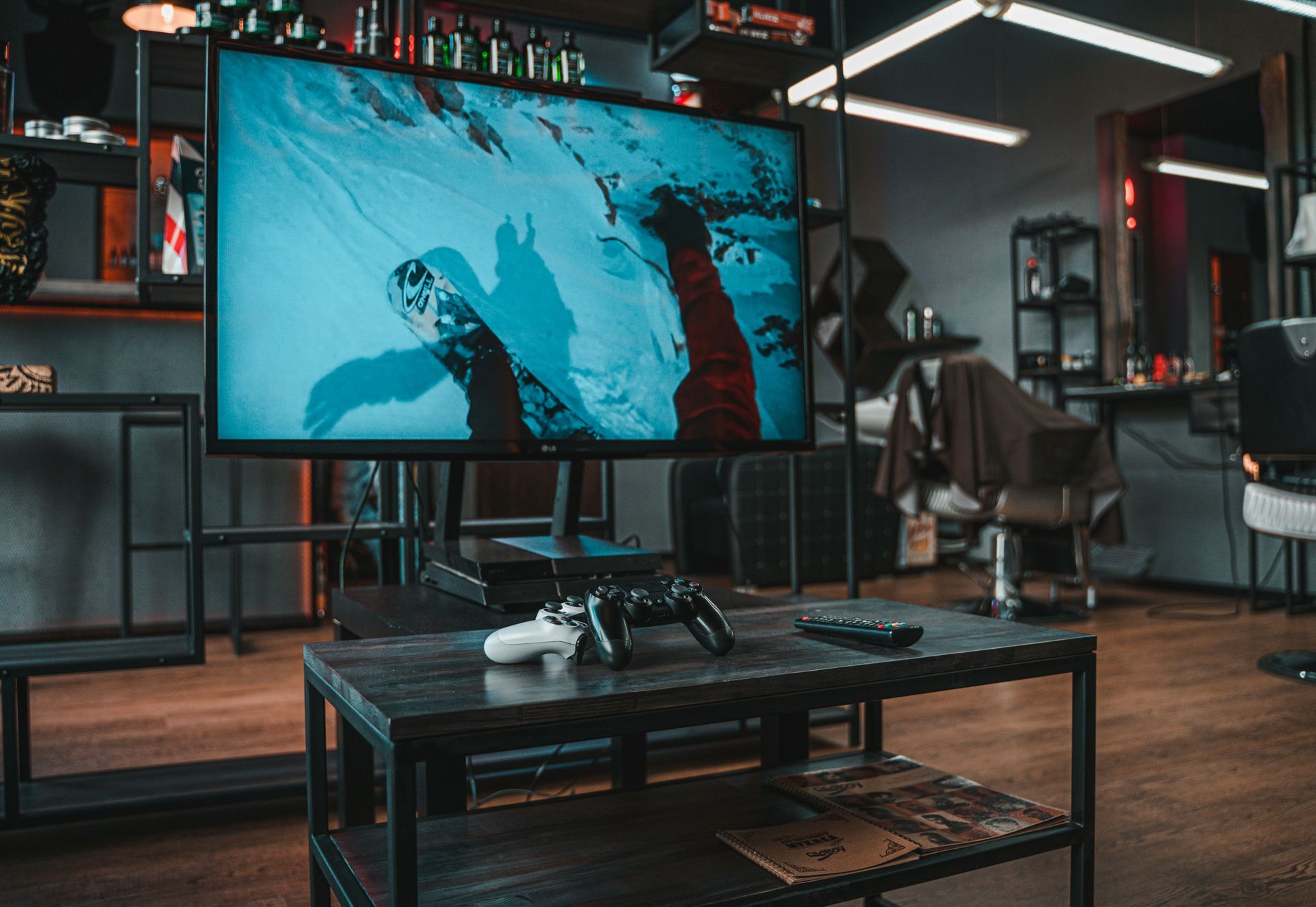Television with a video game console in a barber shop. Controller on a table, blue screen.