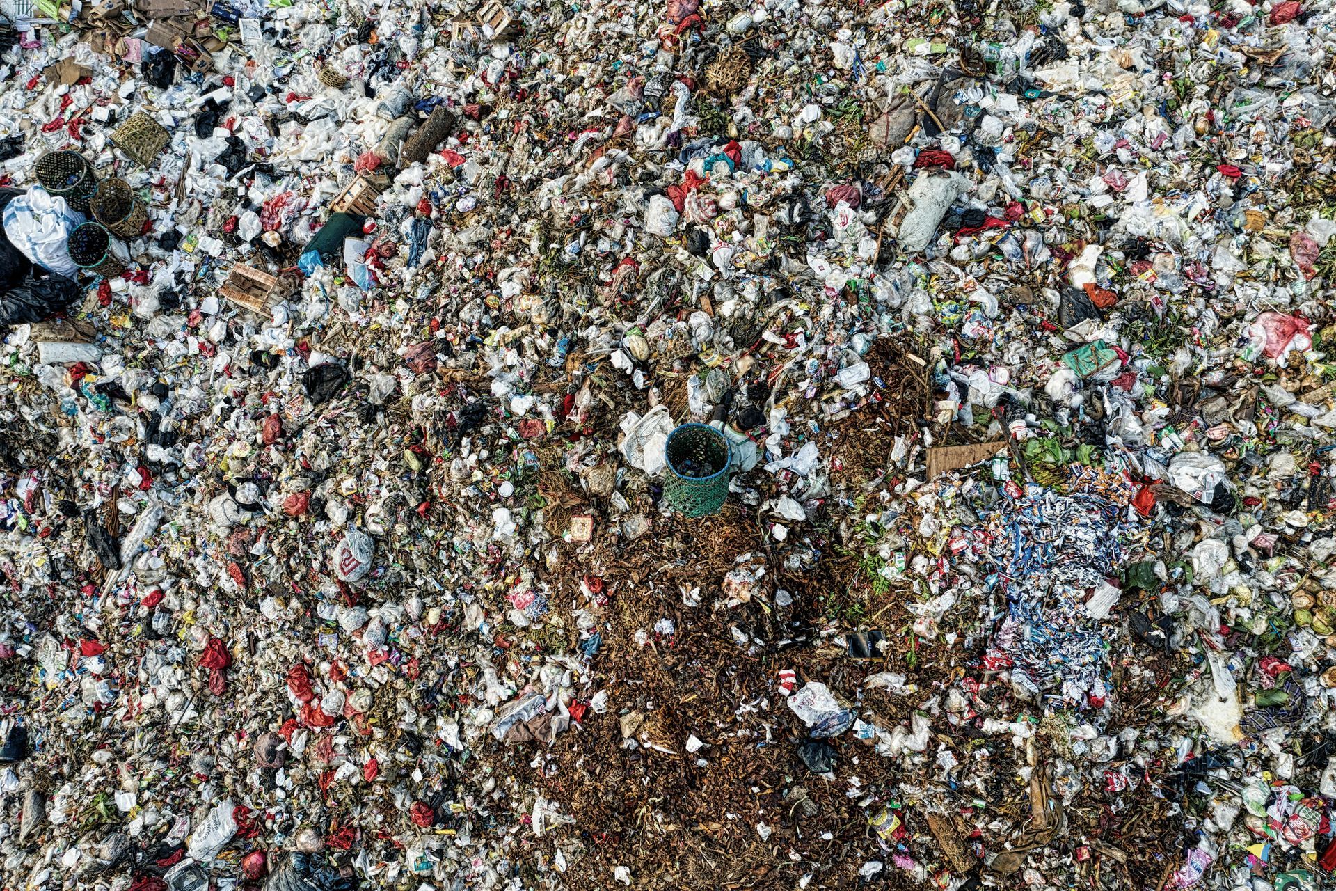 Pile of mixed trash and debris, mostly gray with scattered colorful bits.