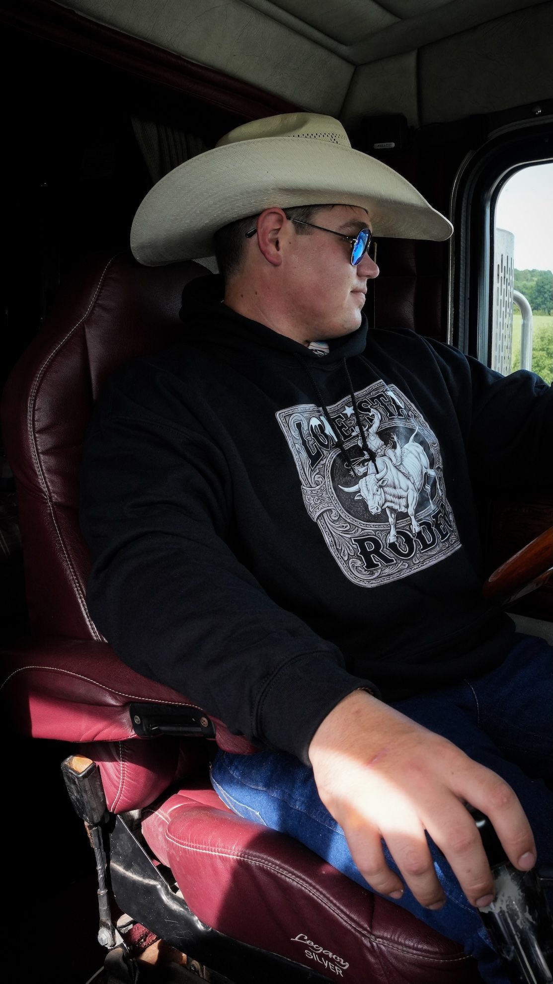 A man wearing a cowboy hat and a sweatshirt that says legendary