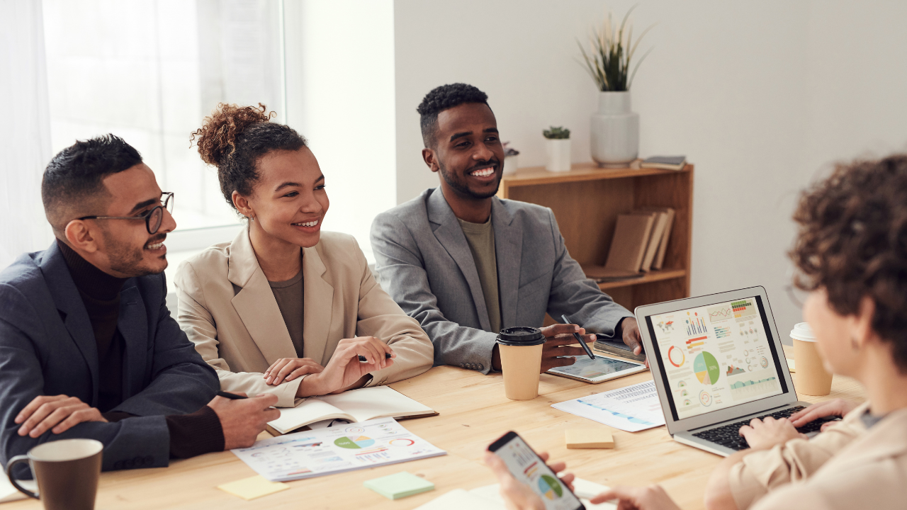 A group of people are sitting around a table having a meeting.