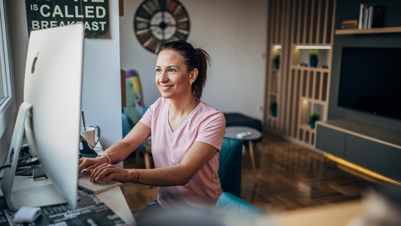 A woman is sitting at a desk in front of a computer.
