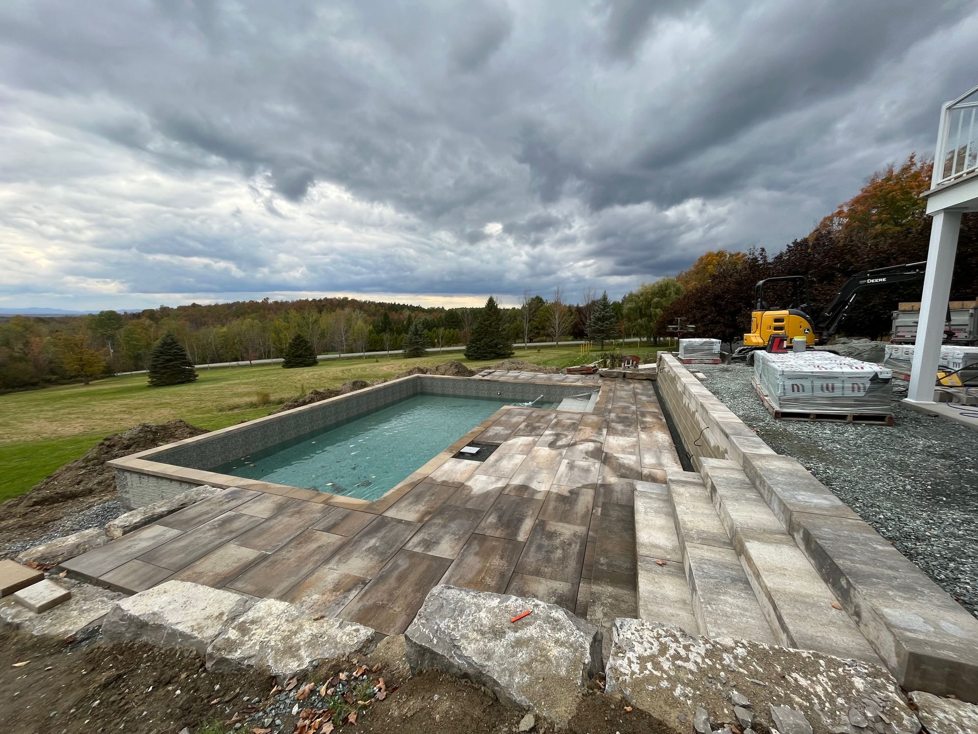 Une grande piscine est en cours de construction dans l'arrière-cour d'une maison.
