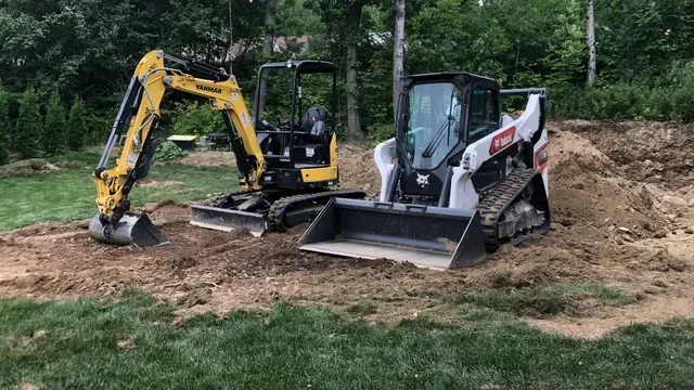 Un camion est garé sur une route de gravier à côté d'un bulldozer.