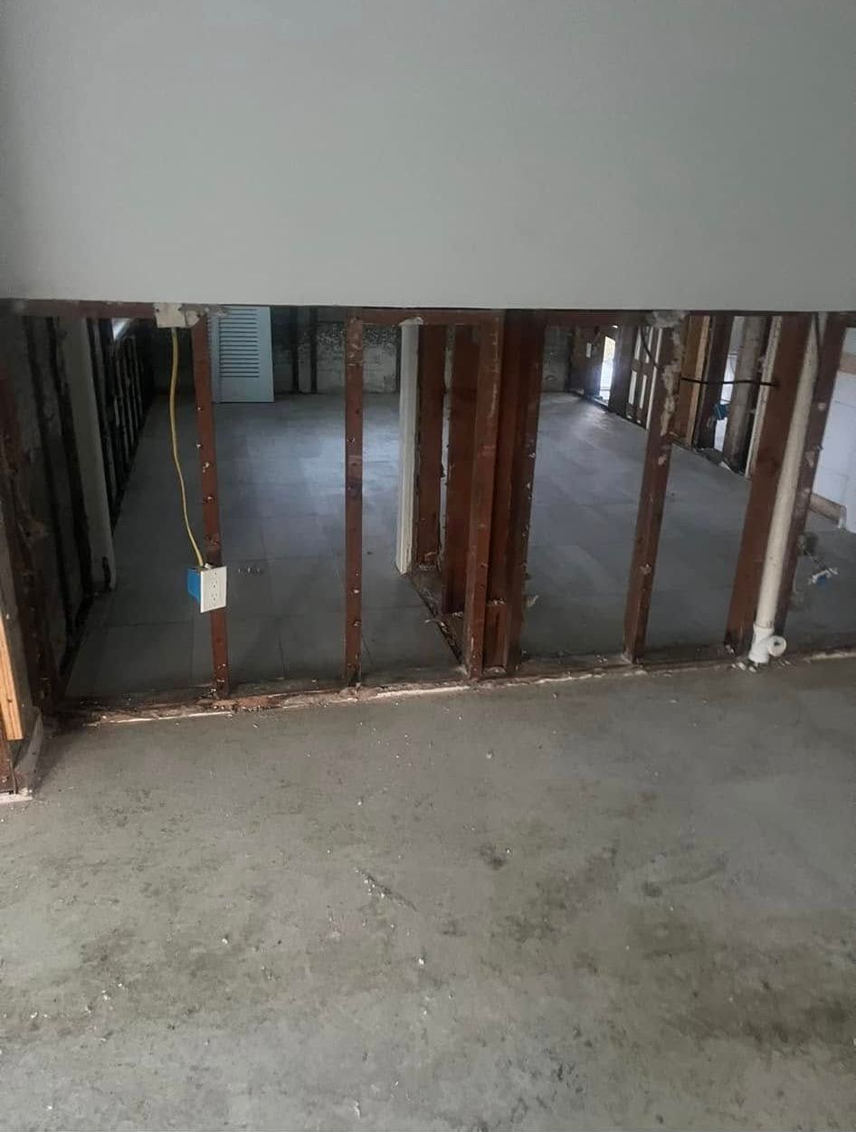 A room with a hole in the wall and a concrete floor.