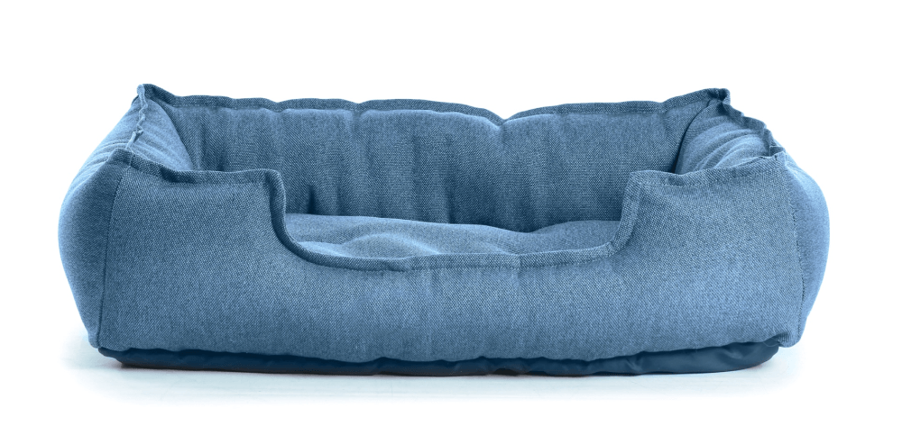 Blue, plush rectangular dog bed on a white background.