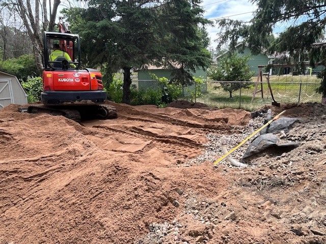 Man is Driving a Red Excavator in a Dirt Field — North Branch, MN — Hassle Free Septic Man is Driving a Red Excavator in a Dirt Field — North Branch, MN — Hassle Free Septic